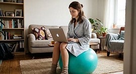 Девушка сидит за ноутбуком и выбирает какую онлайн-профессию освоить ей с нуля